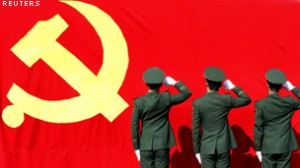Paramilitary policemen hold their fists in front of a flag of Communist Party of China as they attend an oath-taking rally to ensure the safety of the upcoming 18th National Congress of the Communist Party of China, at a military base in Hangzhou