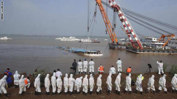 This photo taken on June 5, 2015 shows rescuers looking on as cranes raise the sunken ship "Eastern Star" at the disaster site in Jianli, central China's Hubei province.  A total of 396 people have been confirmed dead after a cruise ship capsized in China, state media said, making it the country's worst shipping disaster in nearly 70 years. AFP PHOTO   CHINA OUT        (Photo credit should read STR/AFP/Getty Images)
