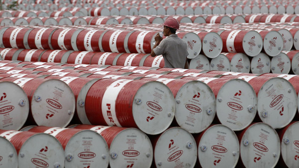 A worker walks in between oil barrels at Pertamina's storage depot in Jakarta in this January 26, 2011 file photo.  To match Special Report CHINA-CORRUPTION/INDONESIA       REUTERS/Supri/Files  (INDONESIA - Tags: ENERGY BUSINESS)